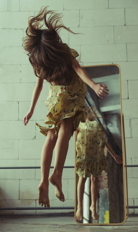 Girl jumping near mirror mystical